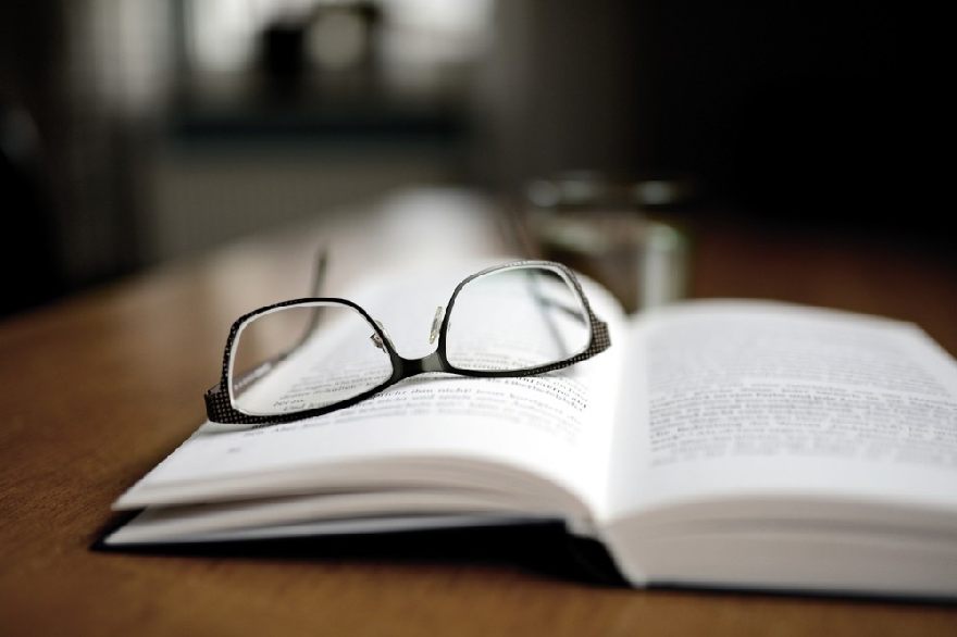 An open book with a pair of glasses on it