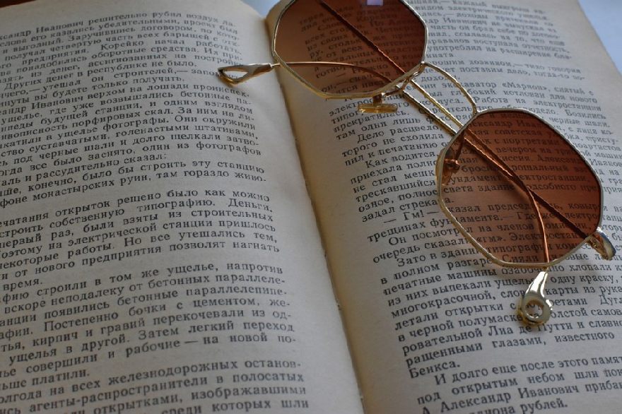 Half-dark brown sunglasses on an open book