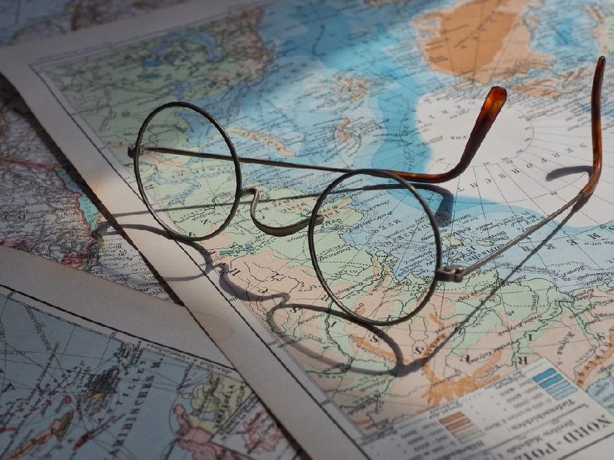 Round glasses on an open atlas