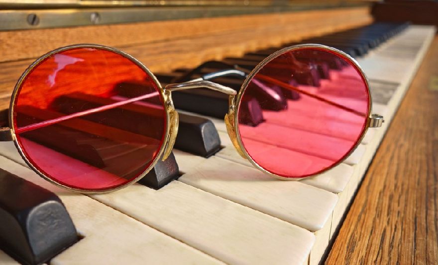 Red glasses on a piano