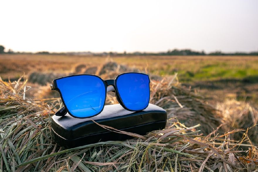 Lunettes de soleil bleues sur une botte de foin