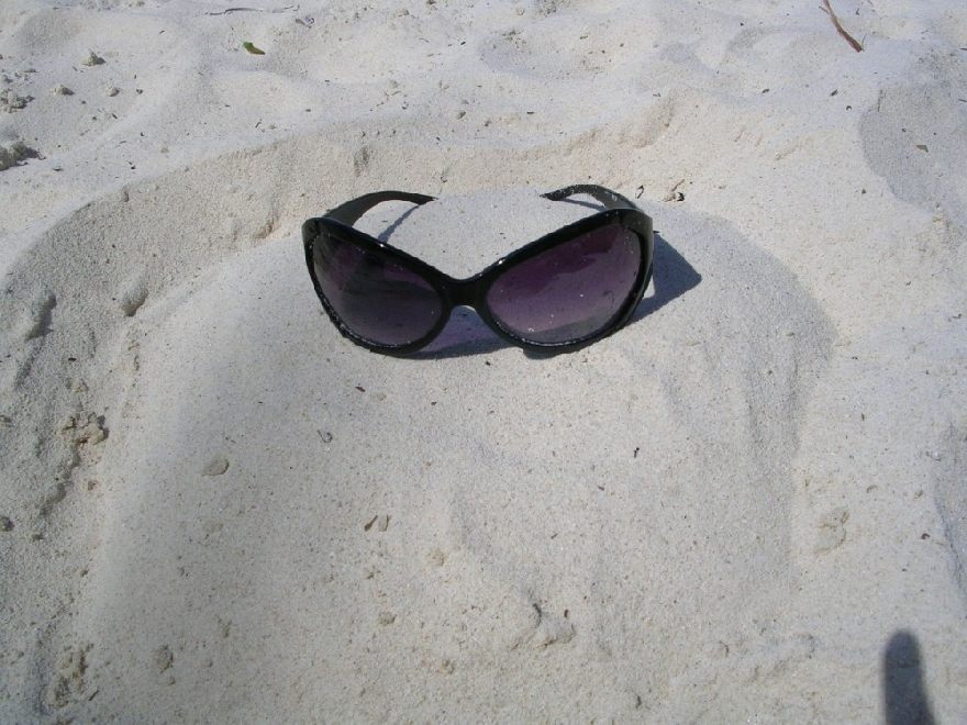 Sonnenbrille im Sand