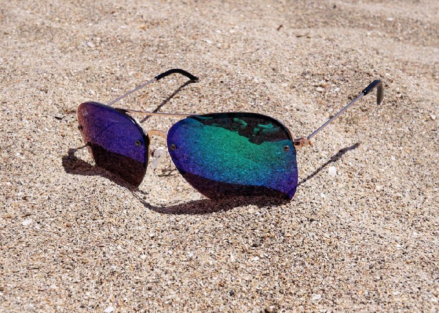 Lunettes de soleil bleues dans le sable