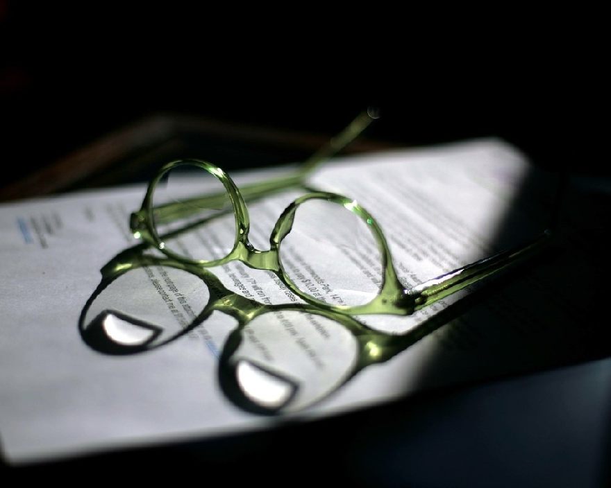 Lunettes vertes sur un livre à l'ombre partielle